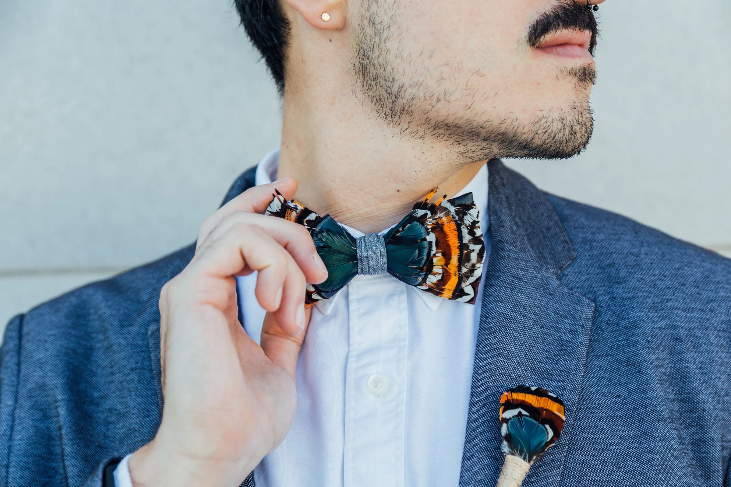 Luis Mandujour Model wearing a mandujour feather bow ties and lapel pin