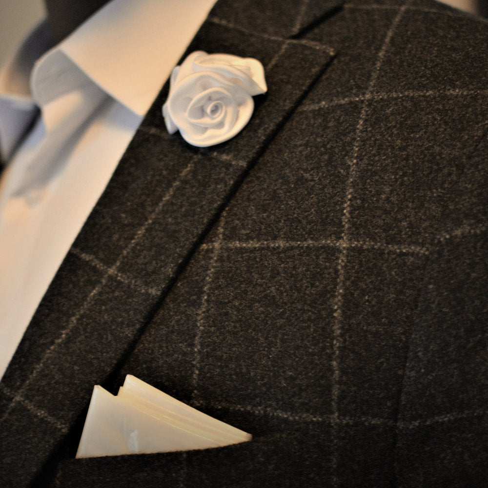 Flower lapel pin on a plaid suit jacket